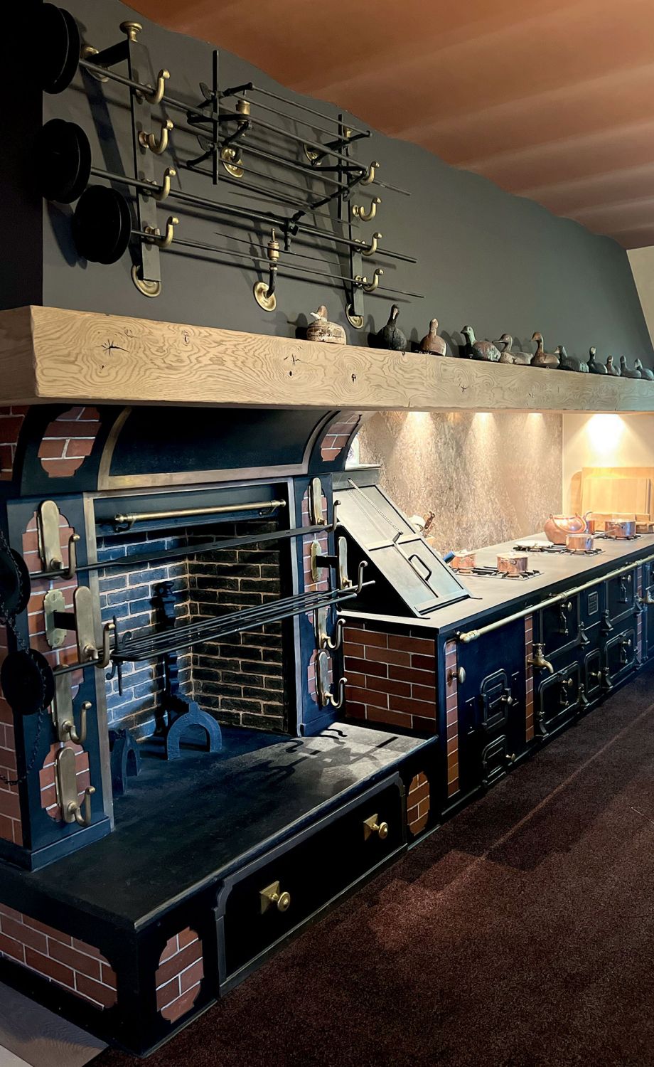 Cuisine avec cheminée et fourneau de cuisson et mur en brique